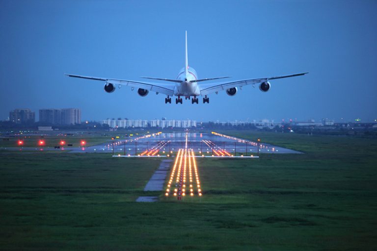 Uma foto aérea do Aeroporto Internacional de Guarulhos, com aviões decolando e pousando em um dia ensolarado.